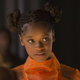 Letitia Wright as Shuri in an orange dress in Avengers: Infinity War.